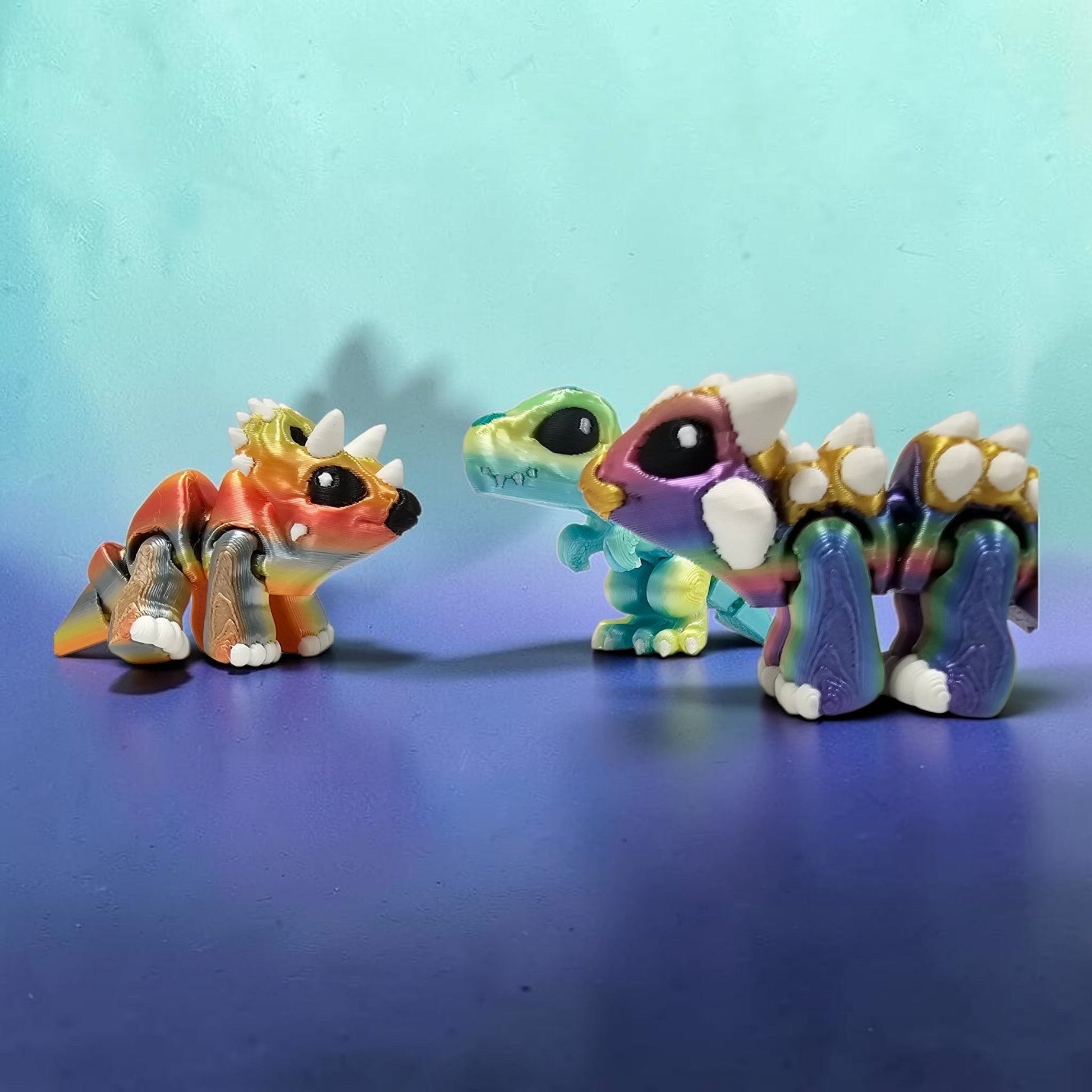 Made In Cobham articulated 3D printed dinosaur figurines in vibrant gradient colours with glossy eyes and flexi bodies.