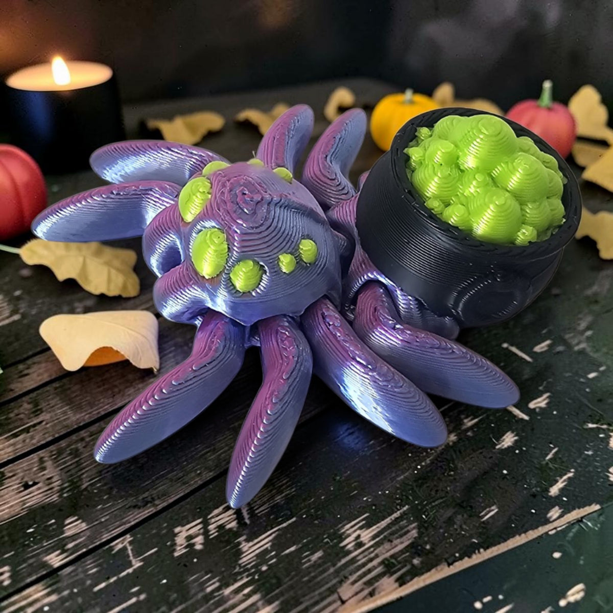 Made In Cobham 3D-printed purple and green articulated spider figurine holding a black cauldron of bubbling brew