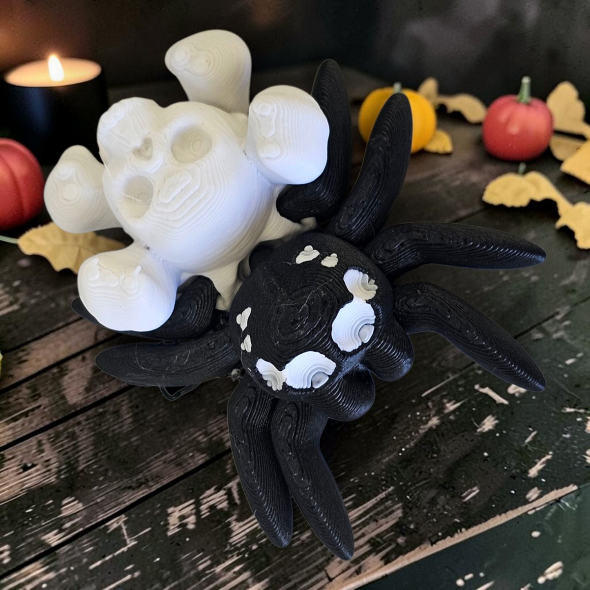 Made In Cobham 3D-printed black and white articulated spider figurine with skull motif on a rustic wooden surface.