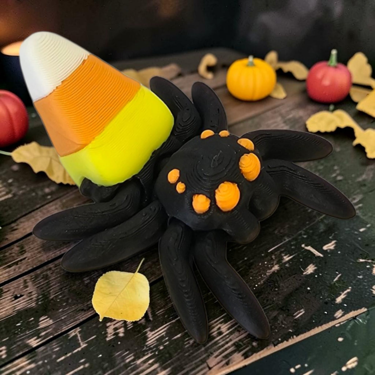 Made In Cobham 3D-printed black spider figurine with a candy corn body and articulated legs for Halloween decor
