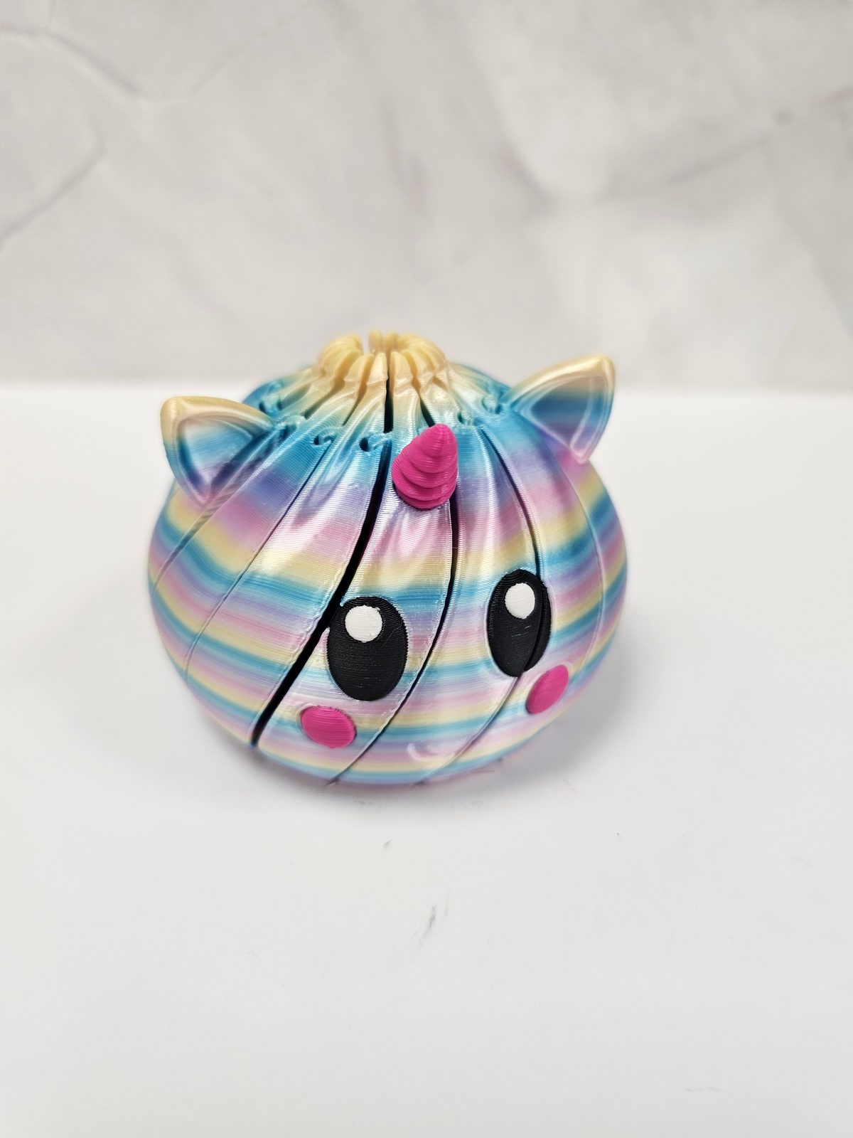Made In Cobham articulated rainbow unicorn fidget sphere with a segmented design for sensory play and stress relief.